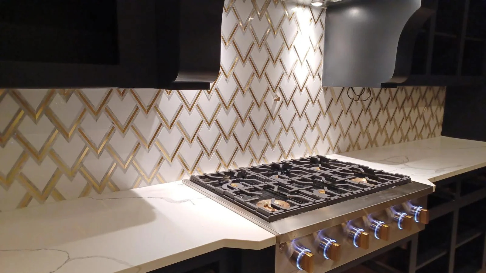 Chevron pattern backsplash with brass accent trim — Boca Raton, FL
