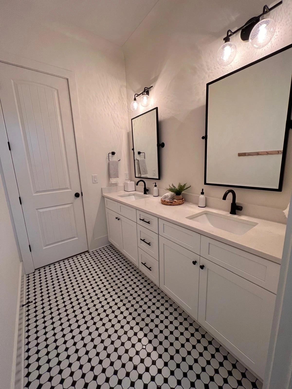 Double vanity with black-framed mirrors and mosaic tile flooring — Hollywood, FL