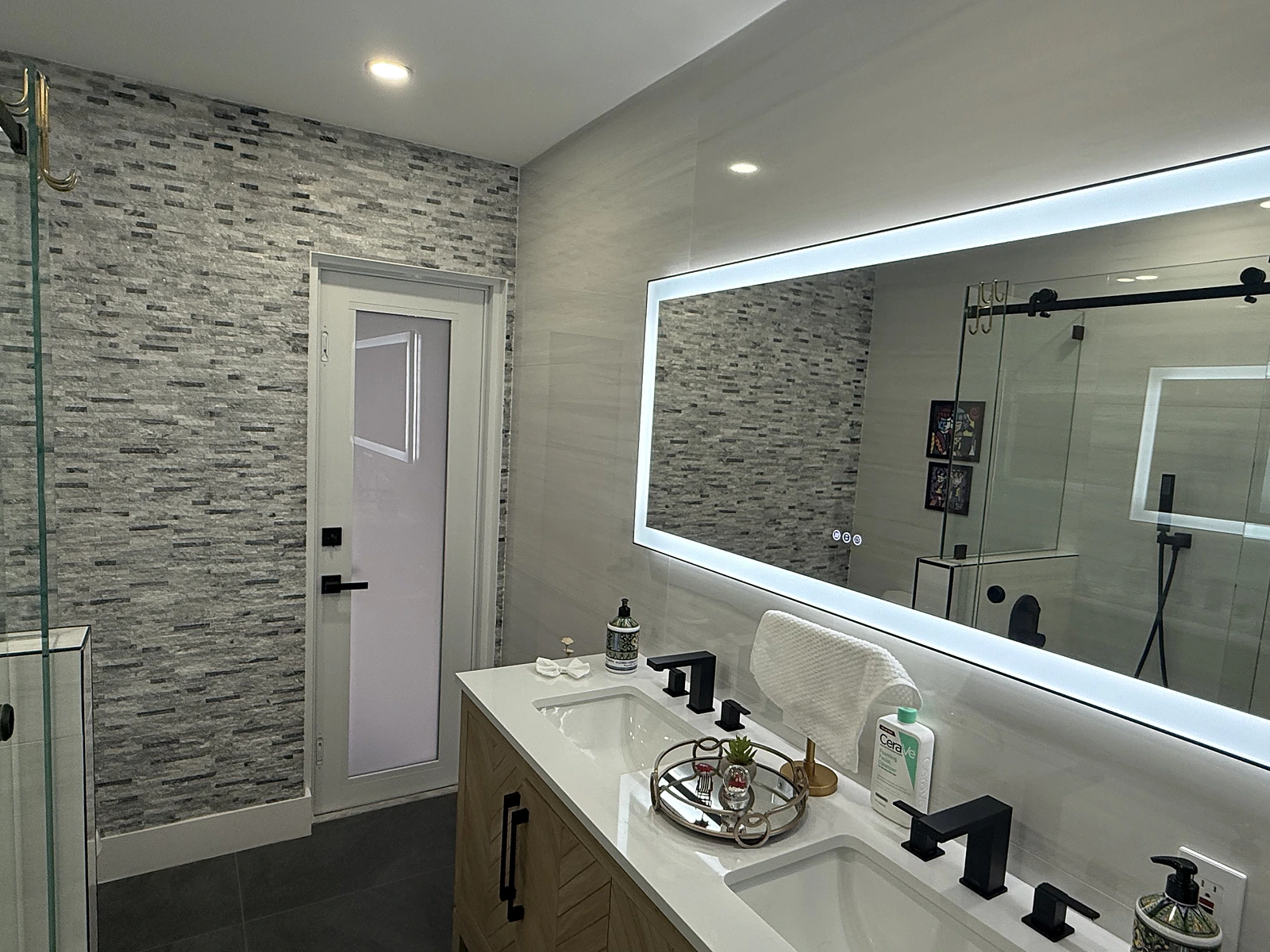 Double vanity with a wide backlit LED mirror and mosaic accent wall — Miami, FL