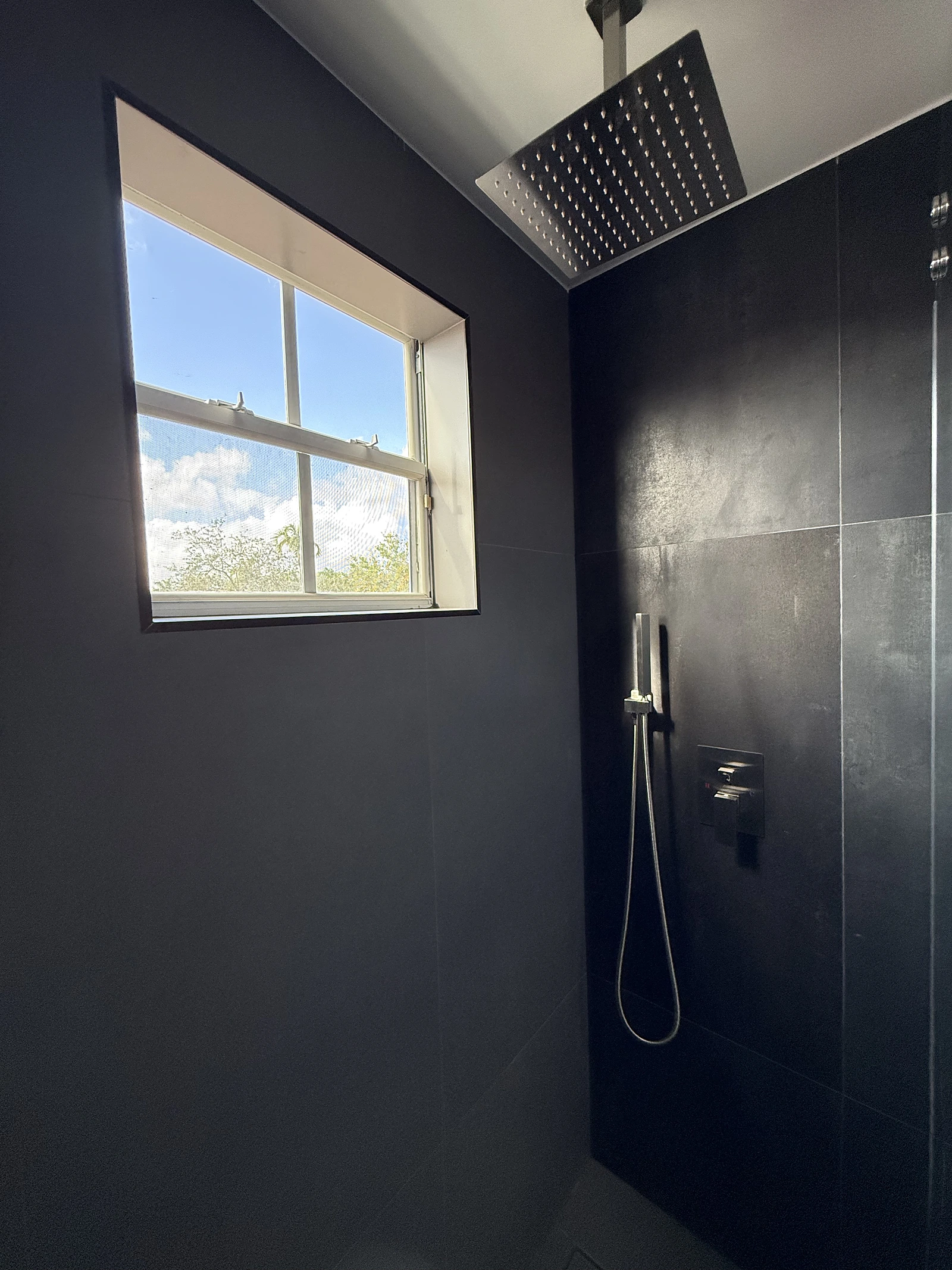 Dramatic black tile shower with rain head and window — Boca Raton, FL