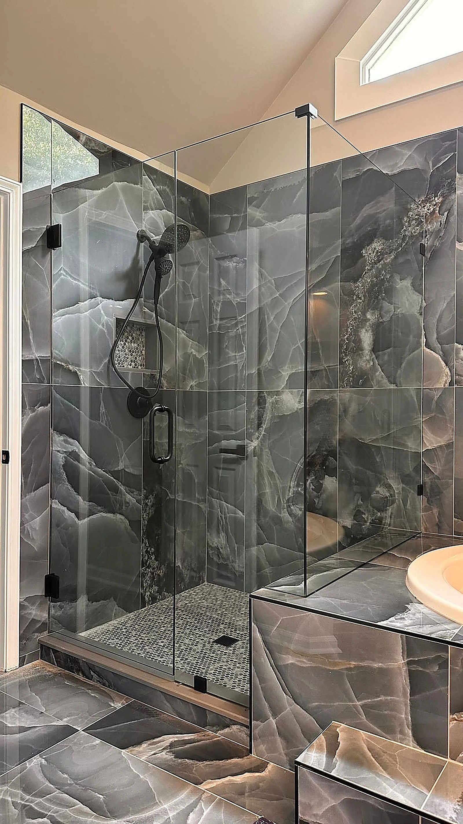 Glass shower with dark veined marble tile in a South Florida remodel — Weston, FL