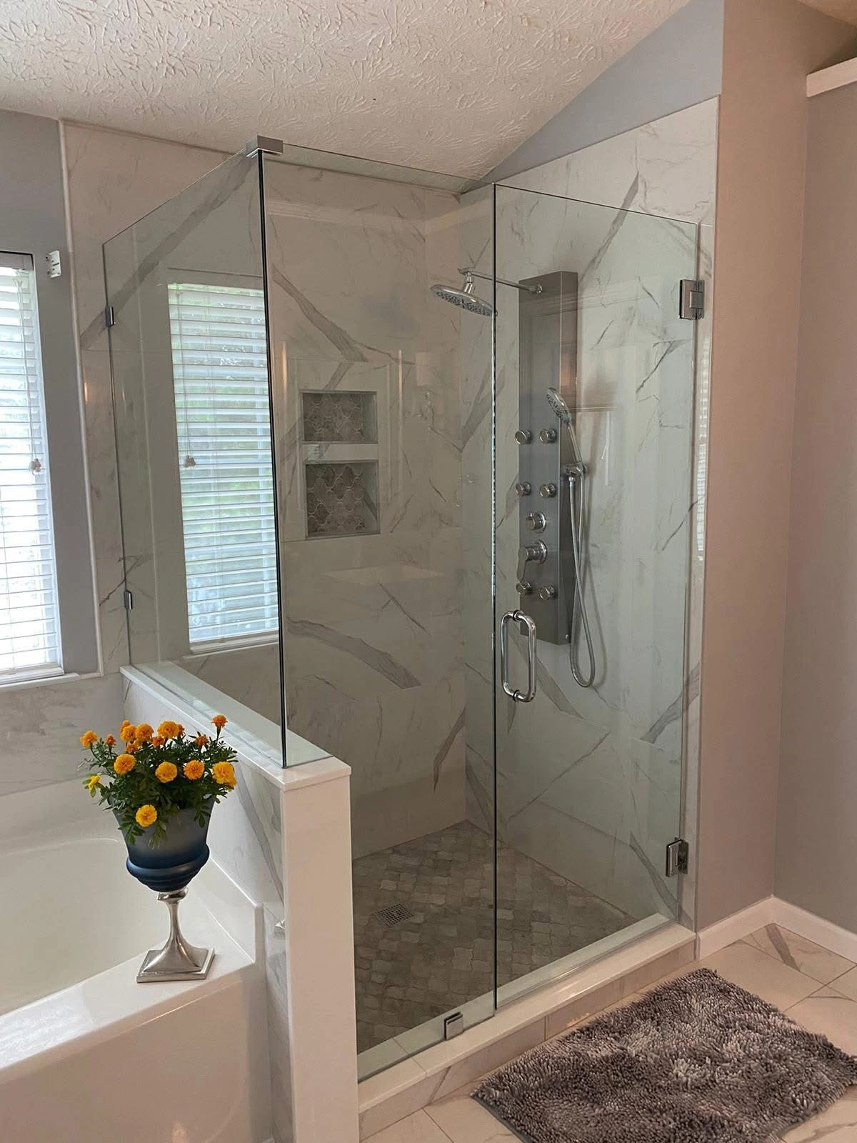 Corner glass shower with marble walls and mosaic floor — Delray Beach, FL