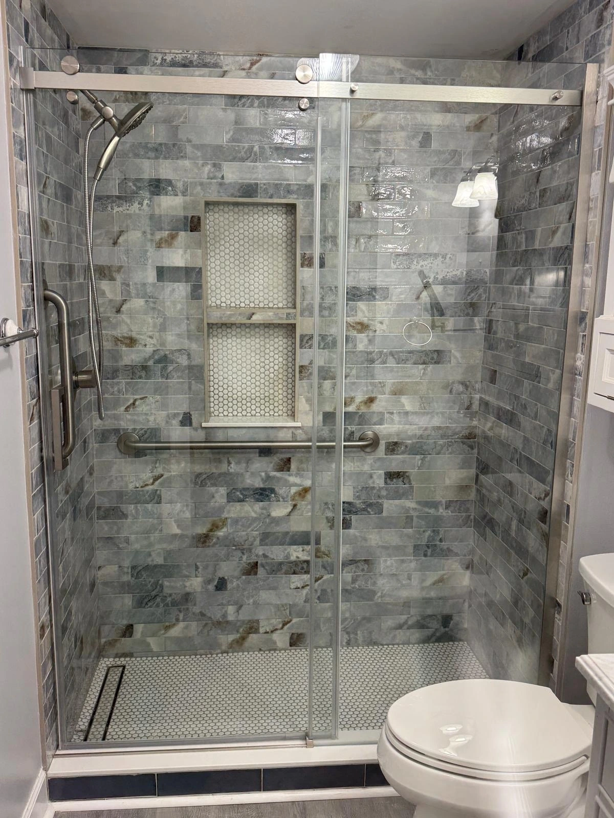 Glass-enclosed shower with green slate tile and built-in niche in a Broward County home — Deerfield Beach, FL
