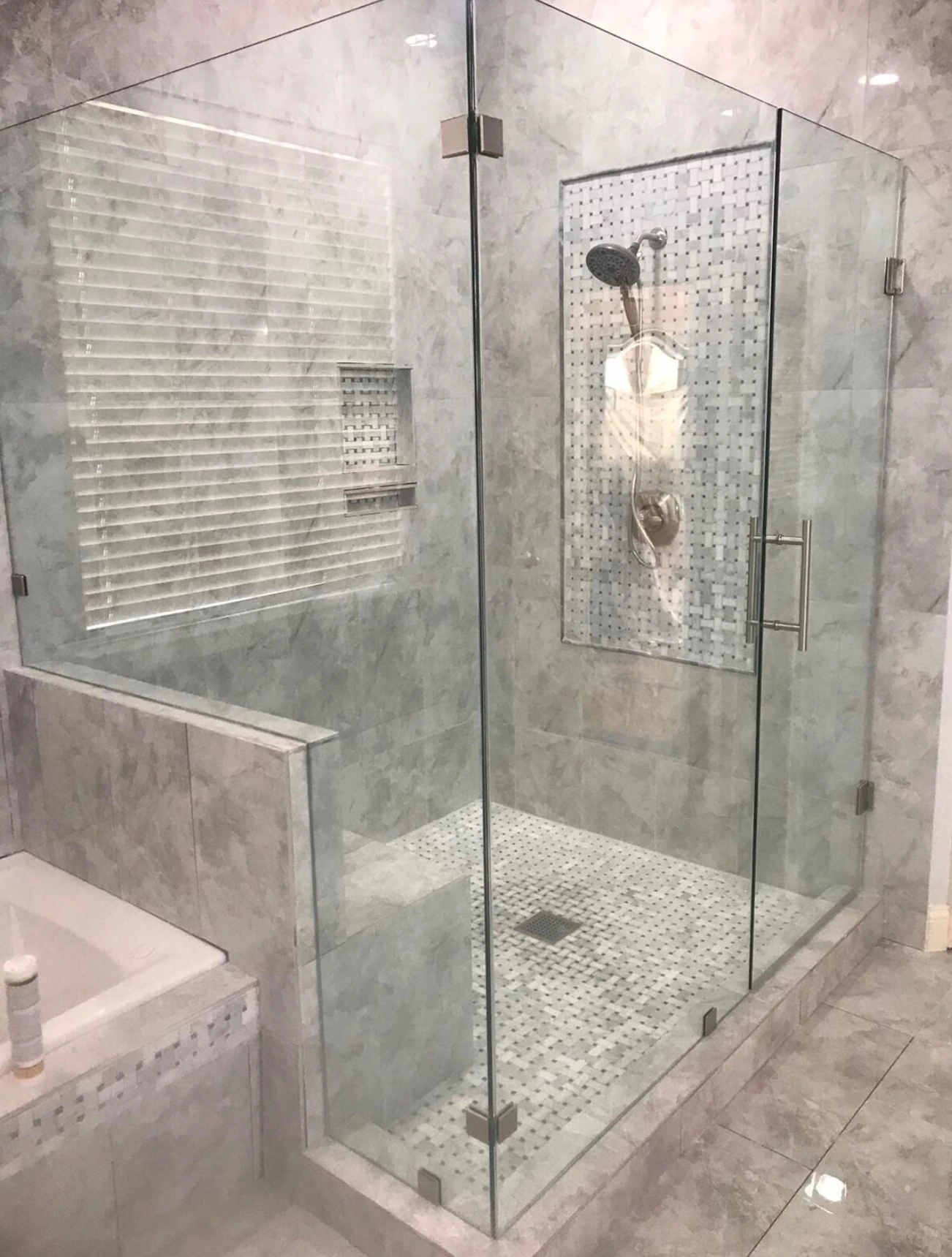 Glass shower enclosure beside a built-in soaking tub — Miami, FL