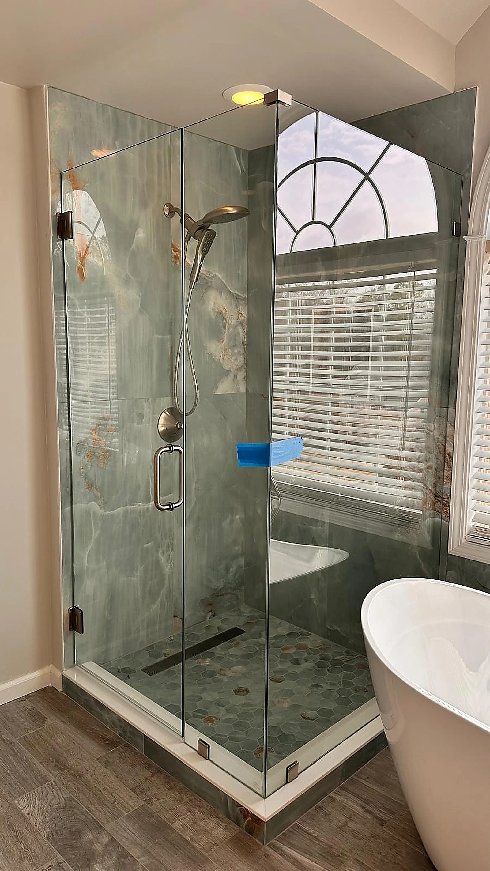 Green-veined marble shower beside a freestanding tub — Aventura, FL