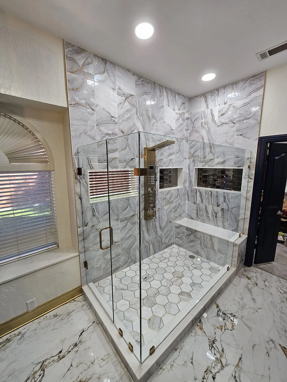Marble shower and freestanding tub with brass fixtures