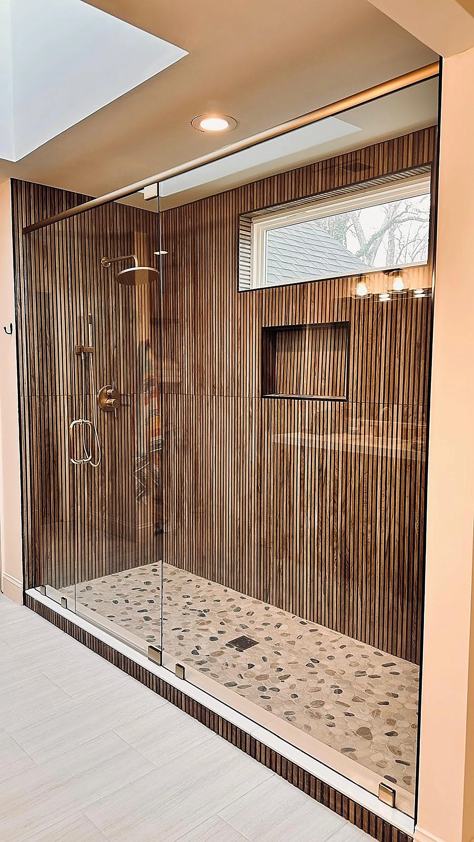 Ribbed wood-look tile shower with brass rain shower fixtures — Pembroke Pines, FL