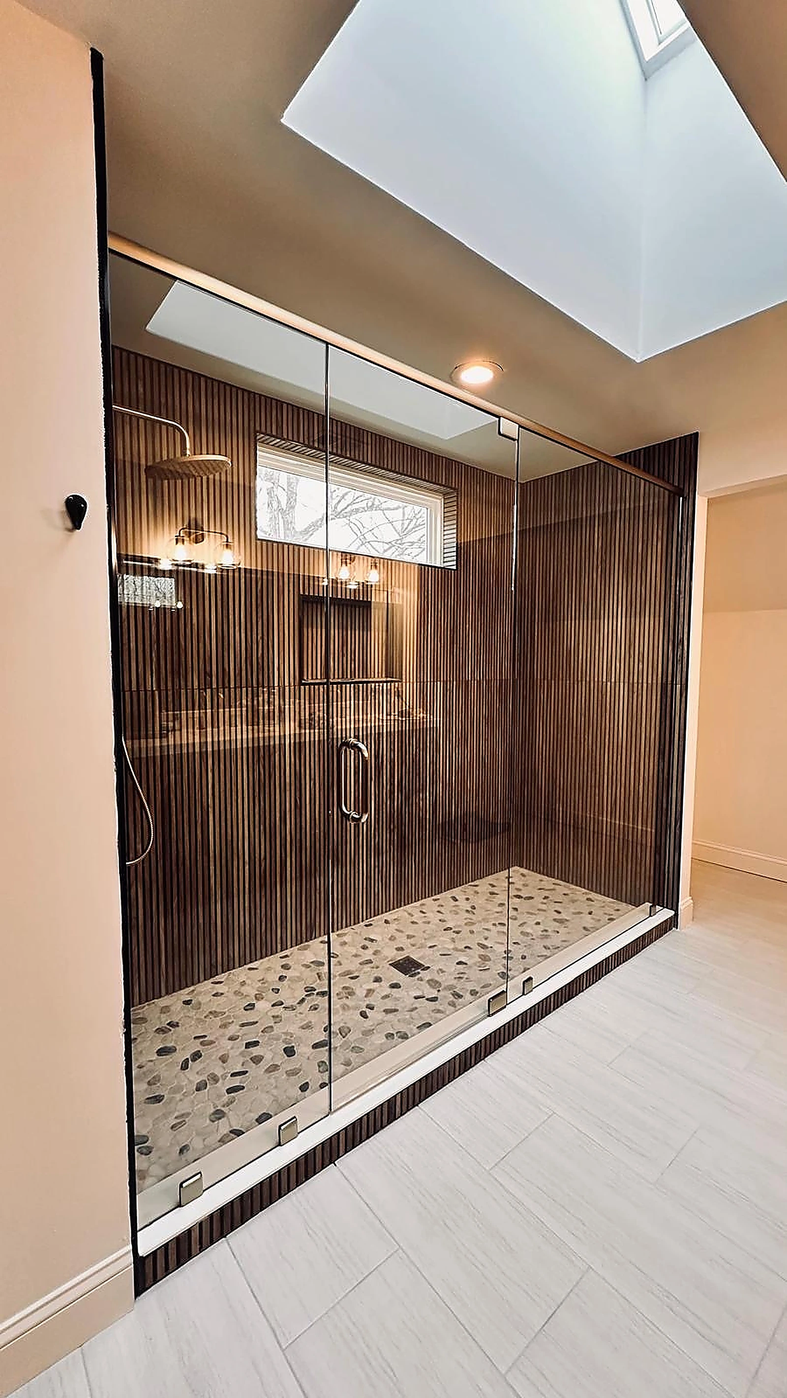 Wood-look ribbed tile shower with framed glass door and pebble floor — Plantation, FL