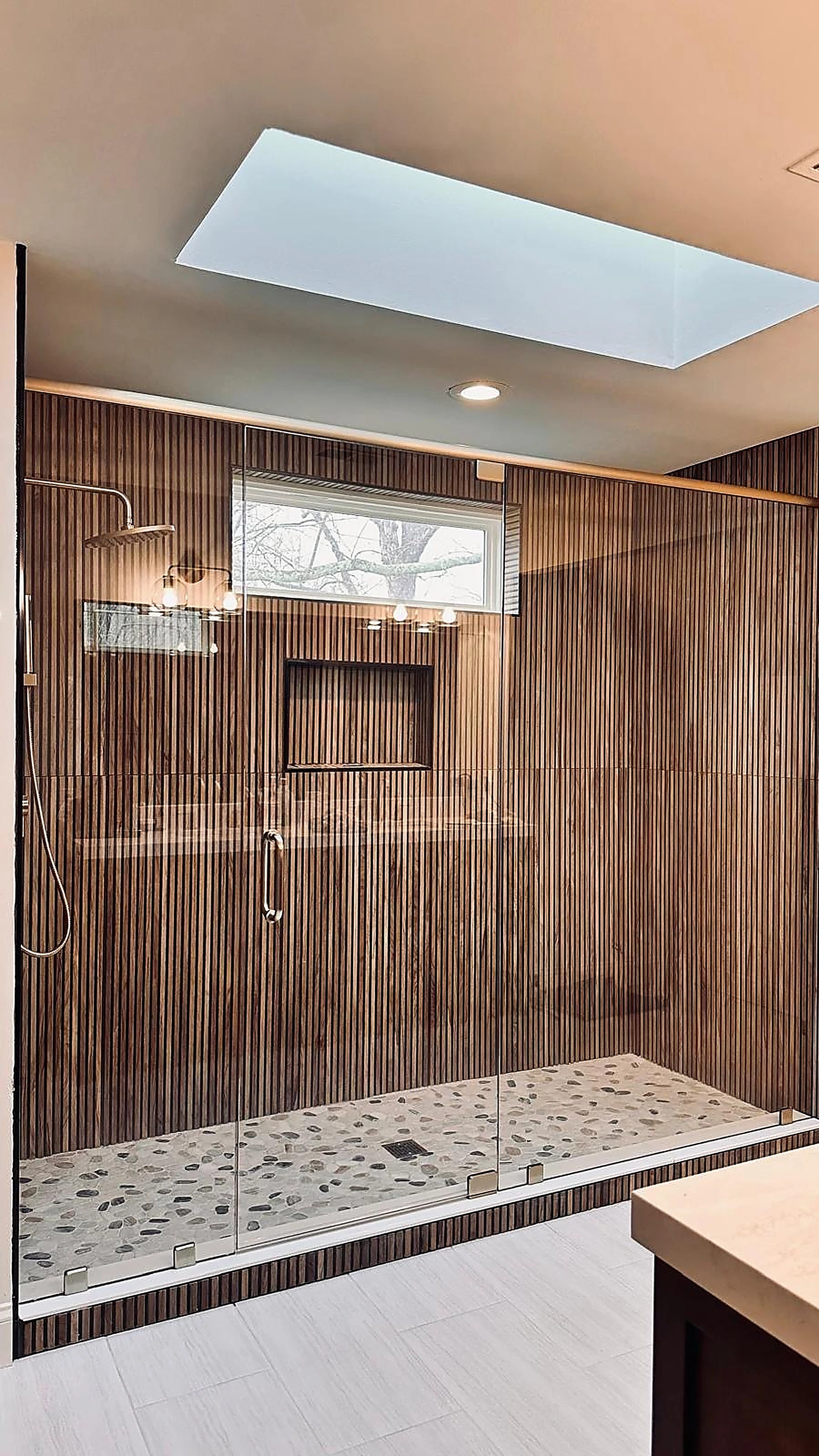 Wide walk-in shower in ribbed wood-look tile beneath a skylight — Hollywood, FL
