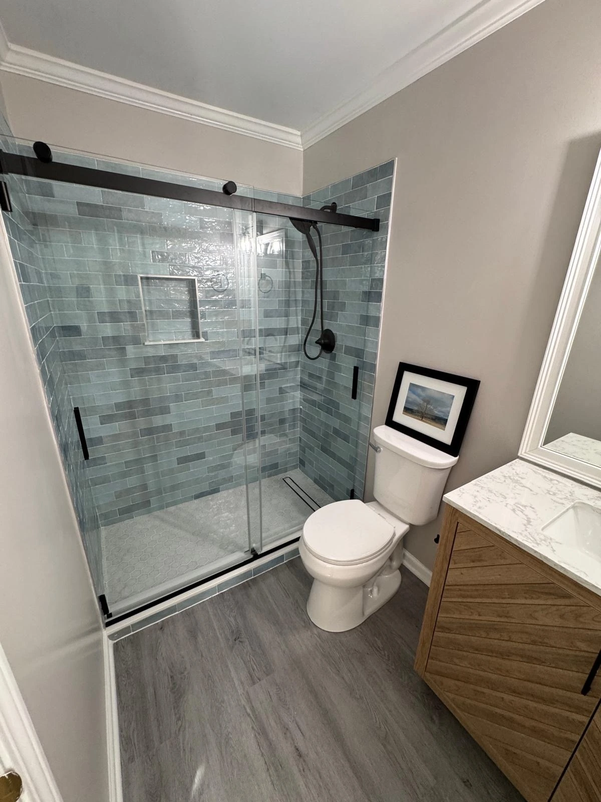 Sliding glass shower with teal tile and a wood floating vanity — Hollywood, FL