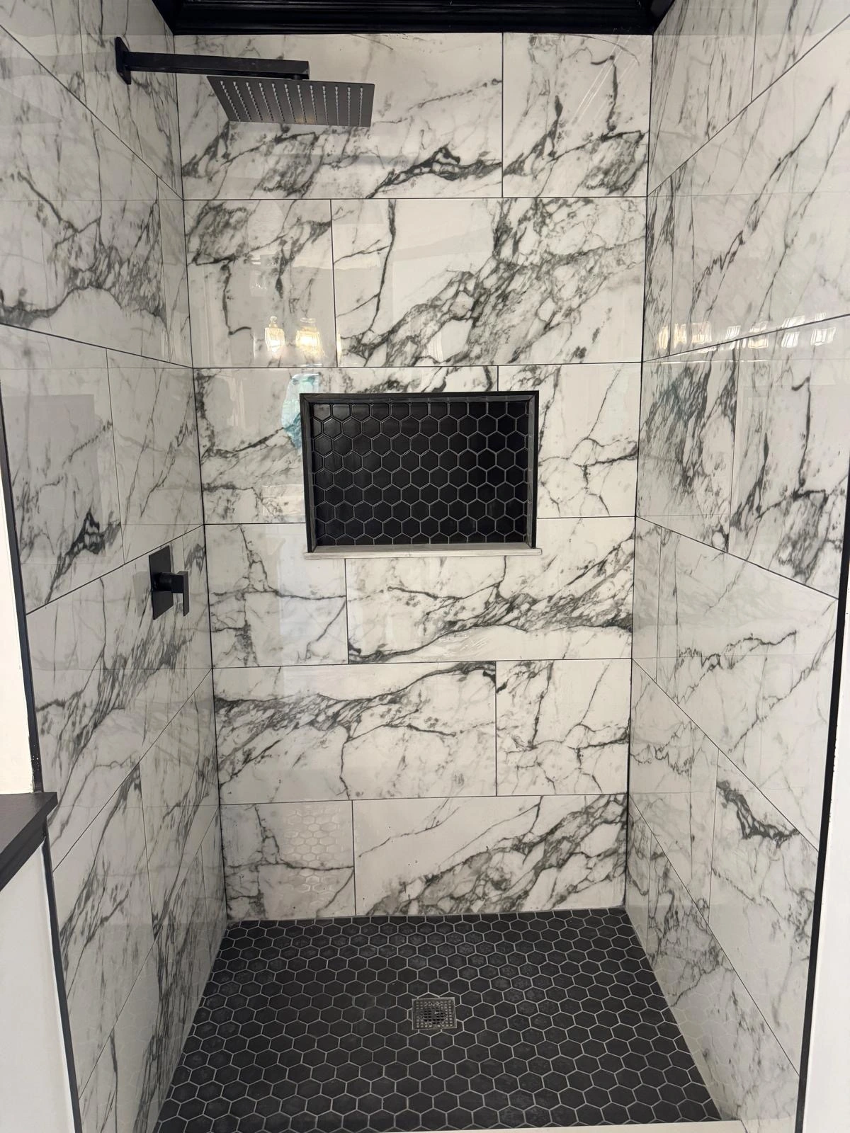 White marble shower with black hexagon pan and matte black fixtures — Plantation, FL