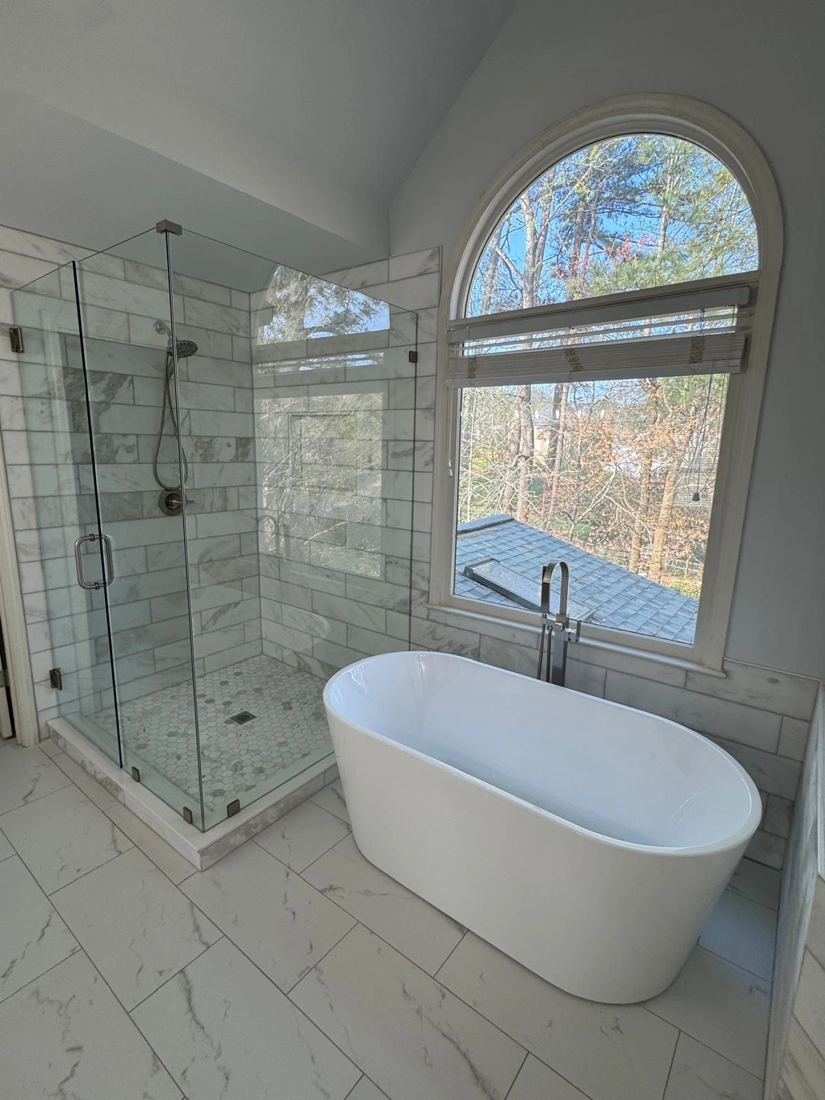 Freestanding tub and glass shower beneath an arched window — Plantation, FL