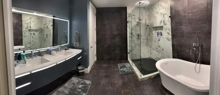 Wide master bathroom with double floating vanity and freestanding tub