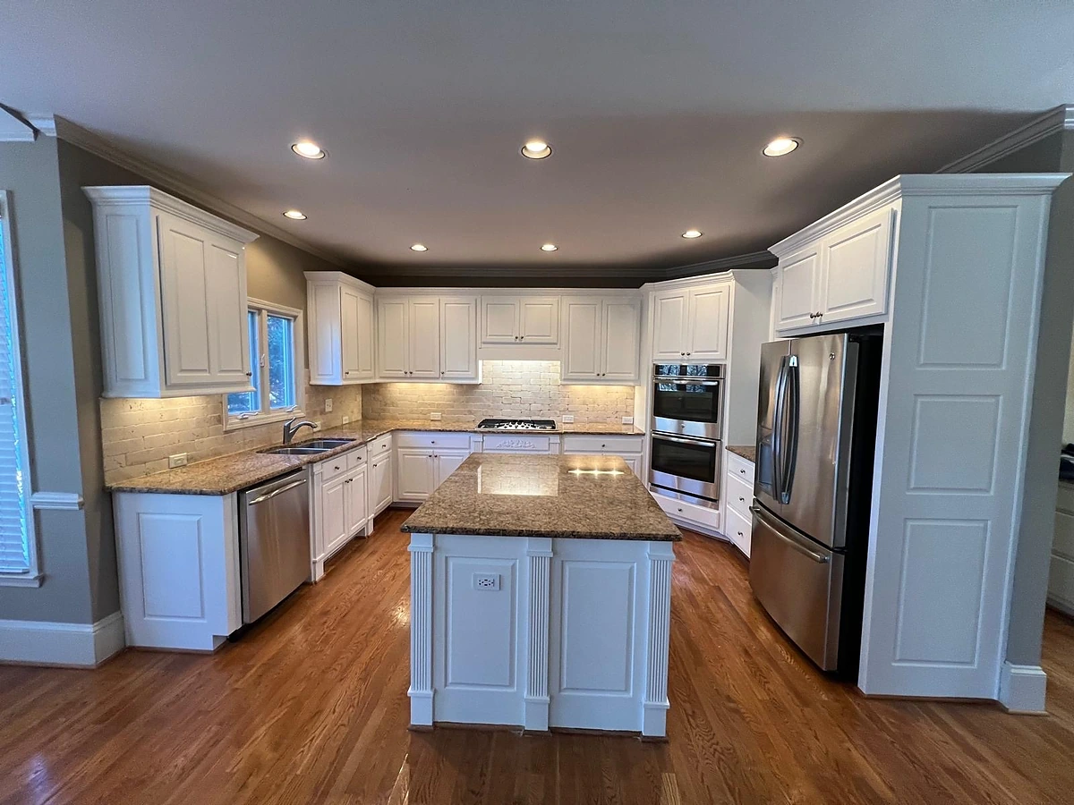 Traditional kitchen with cream cabinetry, granite countertops and a center island on hardwood floors