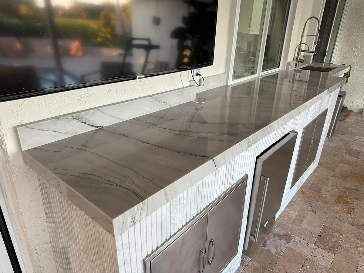 Outdoor kitchen counter in marble-look quartzite with stainless storage cabinets