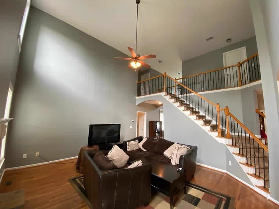Full living room interior painting with accent wall and staircase in South Florida by Primer Star Corp