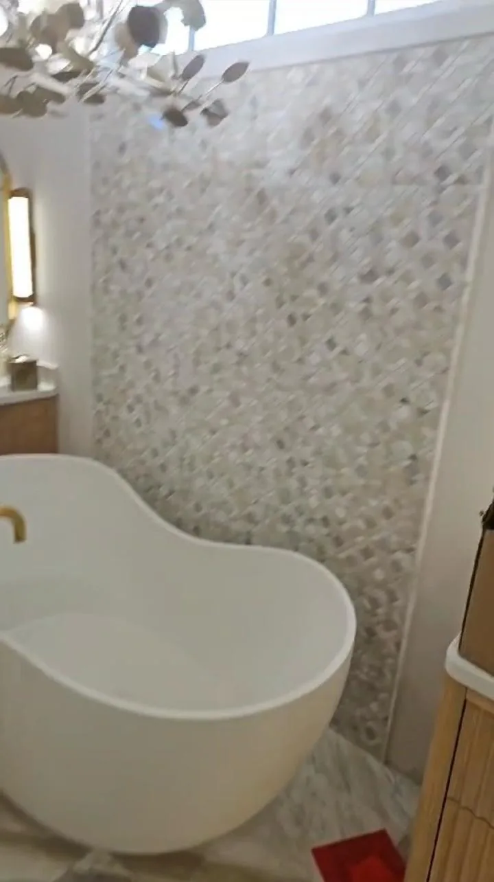 Luxury freestanding soaking bathtub installation with marble surround in premium South Florida bathroom