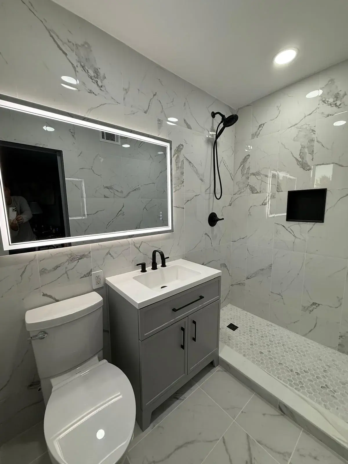 Complete modern bathroom remodel with frameless shower, floating vanity, and designer tile in Fort Lauderdale FL