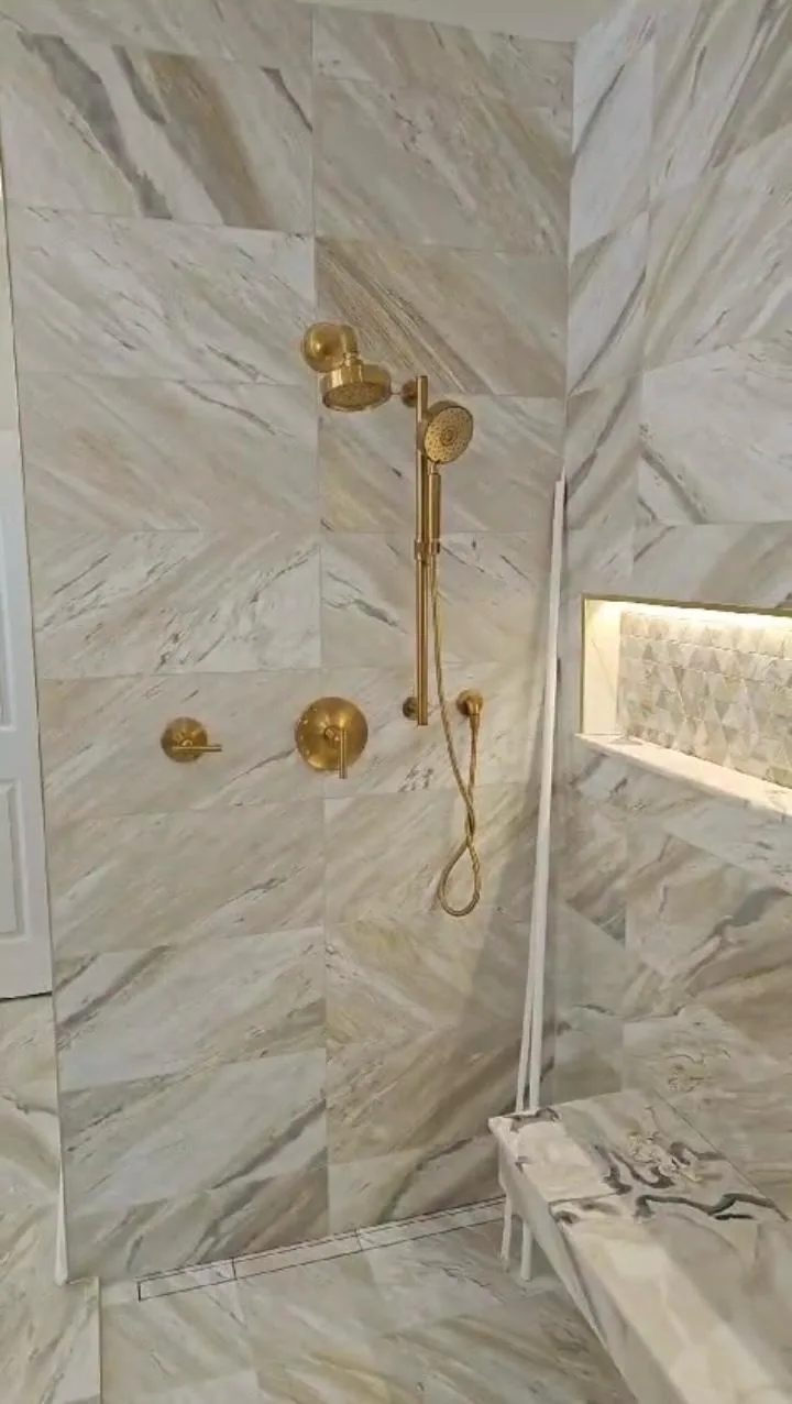 Luxury walk-in shower with brushed gold rain showerhead and fixtures in premium bathroom remodel