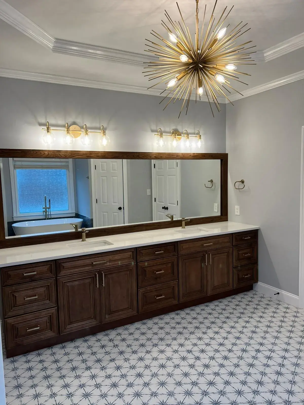 Luxury bathroom remodel featuring sputnik chandelier, floating vanity with vessel sink, and marble tile in Broward County FL